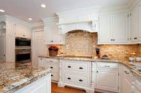 With a beautiful neutral background of light gray cabinets, lightly veined countertops, and a white tile backsplash, we just can't take our eyes off the bright gold cup pulls and knobs. Classic White Traditional Kitchen Plain Fancy Kitchen Decor Grey Classic Kitchen Cabinets Classic White Kitchen