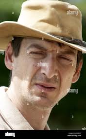 Walter Holt Young man with hat squinting in bright sunshine Stock Photo