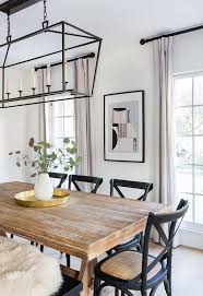 Black French X Back Chairs Surround A Brown Wooden Trestle Dining Table Illuminated By A Darl In 2020 Brown Dining Room Modern Farmhouse Dining Room Dining Table Black