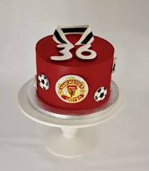 Chocolate cake with hand cut man utd logo, with matching vanilla cupcakes. Manchester United Birthday Cakes