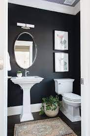 Stacked Zebra Print Hangs From A Black Wall Above A White Porcelain Toilet Fixed To A Dark Stai Powder Room Remodel Half Bathroom Decor Small Bathroom Makeover