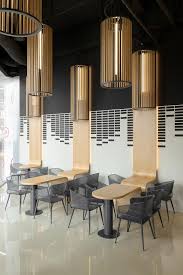 What would a living room be without the welcoming presence of a coffee table? The Custom Designed Tables In This Cafe Are Like A Ribbon That Wraps Around Onto The Wall