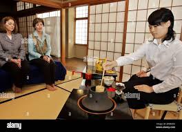 U.S. first lady Laura Bush, 2nd left, accompanied by the wife of U.S.  Ambassador to Japan Susanne Schieffer, left, attends a Japanese tea  ceremony performed by a school girl, right, of the