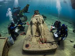 Off the rugged coast of Alexandria, deep under the waves, divers uncovered  what appears to be a submerged temple, an elaborate structure with a majestic  mermaid statue seated on a carved throne.