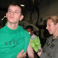 U.S. Navy Aviation Maintenance Administrationman 3rd Class Joshua Hardin  (left) assigned to the"Sunliners"of Strike Fighter Squadron 81, receives an  Influenza vaccination from LT. Nancy Warner (right) assigned to Carrier Air  Wing 11 in the hangar bay ...