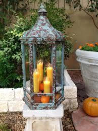 Weathered Turquoise Lantern Filled With Orange Candles Mini Pumpkins In The Garden At Casa Jacaranda Lanterns Decor Candle Lanterns Orange Candle
