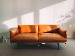 Download the perfect sofa pictures. 2 Seat Orange Leather Sofa Beside Wall Free Stock Photo