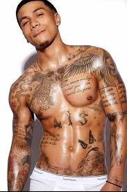 The flowers along either side of the tattoo give it a softer edge, despite it being such a bold and heavy piece. Black Men Tattoos