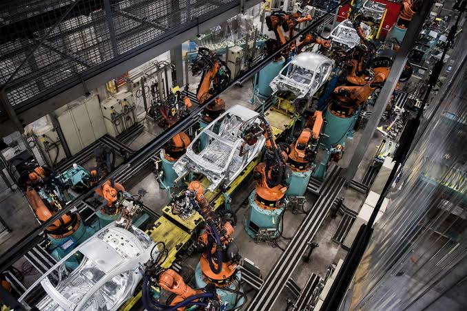 Automated articulated arms on an automotive line, AI generated