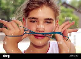 MR 598 Young student Avery Cox plays a quick round of cat's whiskers, while  relaxing at Fine Art Days in Lincoln, New Mexico Stock Photo