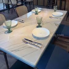 The reddish metal colour of the stone table makes a good contrast with the floor and cabinet. China Modern Quartz Stone Top Dining Tables China Dining Table Table Top