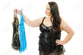 Mujer Adulta Madura Con Lencería De Satén Recogiendo Ropa De Dormir. Mujer  De Talla Grande Que Se Siente Cómoda Con Ropa Interior Sensual. Fotos,  retratos, imágenes y fotografía de archivo libres de