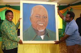 Waziri Mkuu,Kassim Majaliwa akikabidhiwa zawadi ya Rais Dkt. John Magufuli  ambayo ni picha ya Rais iliyochorwa na Mwalimu Elisha Simon wa Ruangwa  (kulia)alipozungumza na viongozi wa CCM na Jumuiya zake wa kata