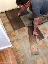 Tile fractures can happen simply due to heavy objects falling on your if one side cannot be adjusted because of the entrance's aestetics, you can lay two 3/4 tile rows (aproximately). How To Install Vinyl Plank Over Tile Floors The Happy Housie