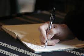 Royalty-Free photo: Person holding ballpoint pen writing on white paper |  PickPik