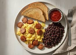 Huevos con salchicha, frijoles negros y pan tostado