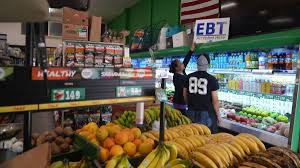 El Recuerdo Market manager Cecilia Benitez sets up a “EBT Accepted Here,” banner in Los Angeles, on Oct. 31, 2025. (Damian Dovarganes / AP via CNN Newsource)
