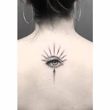 The artist has perfectly recreated the gold highlights within the iris, the delicate and shiny eyelashes and the soft, smoky shading of eye. Micro Realistic Eye Tattoo On The Upper Back
