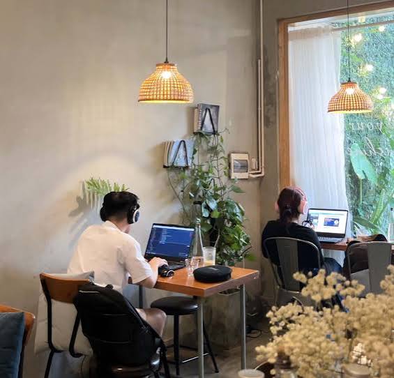 People working from a laptop-friendly cafe