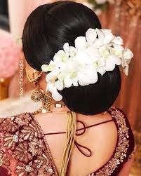 What A Beautiful Large Low Bun With Real Flower Gajra Care However Should Be Taken Before Adopting Such Hairstyles Pink Orchid Studio Bridal Updo Pink Orchids