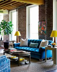 Single teal blue armchair and colorful chevron pattern rug. How To Use Velvet Sofas In Your Living Room Decor