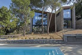Large expanses of glass (windows, doors, etc) often appear in modern house plans and help to aid in energy efficiency as well as indoor/outdoor flow. Butterfly Roof Wedge House By Schema Is Located In A Piny Area In Greece