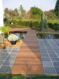 nice decking with pond design by guy wolfs buitentuinen hellende tuin tuin