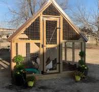 Rustic chicken coop with peaked roof and wire mesh walls
