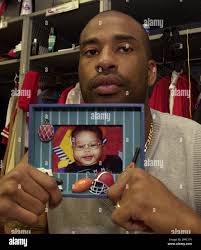 Philadelphia Phillies pitcher Wayne Gomes, who was the fourth overall pick  in the 1993 draft, holds a photo of his son Miles which he keeps above his  locker at the Phillies training