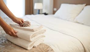 Stack of towels and utiliies for laundry service concept with blank space. The Pros And Cons Of Outsourcing Hotel Laundry Services