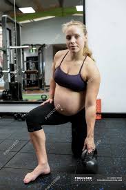 How much weight can a pregnant woman lift in the second trimester? Pregnant Woman Lifting Kettle Bell In Gym Holding Active Stock Photo 228975980