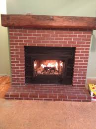 The gate is whitewashed and hung on the wall with a pretty green wreath. Red Brick Fireplace