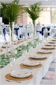 Tropical Wedding Reception With Palm Fronds On Long Guest Tables Wedding Decorations Long Table Wedding Wedding Reception Table Decorations
