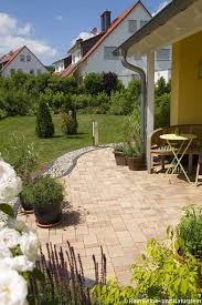 Mediterran Rustikal Gestaltete Aussenanlage Um Das Gelb Gestrichene Haus Organische Formen Und Linien Sind Gartendesign Ideen Gartengestaltung Terrassen Ideen