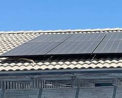 Image of rinsing solar panels with hose