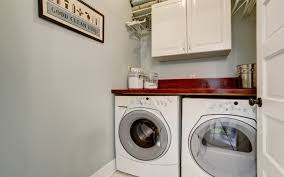 A rich aqua accent wall is offset by a grey mosaic tile wall, creating smooth clean lines to accentuate the vibrant colors. 8 Practical Laundry Room Ideas For Space Efficient Design Mybayut