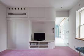 Laptop computer showing green chroma key screen stands on a desk in the living room. Gallery Of Green Screen House Hideo Kumaki Architect Office 14