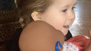 Girl is given doll with hearing aids