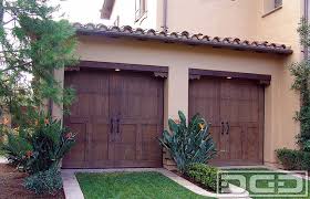 Carriage house collection garage doors combine distinctive carriage house designs and superior insulated steel construction to create a harmonious blend of elegance and strength. California Dream 05 Spanish Style Rustic Select Tight Knot Cedar Garage Doors Mediterran Gartenhaus Orange County Von Dynamic Garage Door