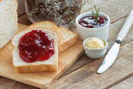 Delicious Toast Bread Served With Butter And Spread With Strawberry Jam On Wood Cutting Board Put On Rustic Wooden Table With Copy Space Homemade Bakery Concept American Breakfast Style Stock Photo Picture