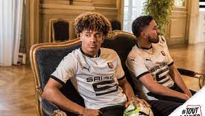 Toujours en partenariat avec adidas, le maillot blanc reste authentique, avec une ligne bleue sur les bras et du orange sur le col, comme les couleurs du club. Photos Stade Rennais Le Club Devoile Son Maillot Exterieur