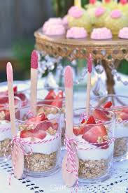 Mini cheesecakes topped with strawberries, pink and white parfaits, pink macarons, cupcakes, and pink champagne. Princess Party Food Ideas Studio Pep