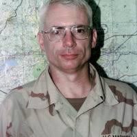 With the media covering the event, University of South Carolina Coach Lou  Holtz chats with STAFF Sergeant (SSGT) Rocky Sutton, USAF, who is preparing  to go through the deployment processing line. In