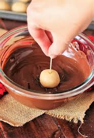 Dipping Crunchy Buckeyes In Melted Chocolate Image Melting Chocolate Chips Buckeyes Recipe Sweet Treats Recipes