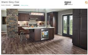 With cherry cabinets, you are automatically working with a strong element of warmth, from within the natural tones of the cherry wood. Pergo Flooring In Warm Grey Oak It Seems To Go Well With Dark Cherry Cabinets Kitchen Remodel Kitchen Flooring Gray Oak Floor