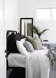black iron bed frame with all white linens black and white striped and army green throw pillows fort fie coastal bedrooms black bed frame coastal bedroom