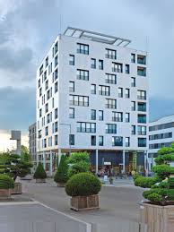 A construction of glulam columns and timber frame elements on steel girder frames develops around a reinforced concrete core. Skaio Riese Mit Kronchen