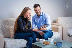 Most relevant best selling latest uploads. Young Couple Laughing Sitting On A Sofa Sharing Information Displayed On An Electronic Tablet With Each Other And Drinking Coffee Stock Photo Picture And Royalty Free Image Image 51965634