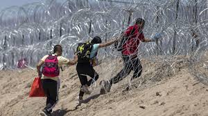 Migrantes atraviesan capas de alambres de púas para cruzar la frontera sur de Estados Unidos