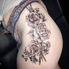 The rose flowers appear to be sitting amongst some leaf vegetation. Floral Thigh Tattoo Thigh Tattoos Women Thigh Tattoo Men Flower Thigh Tattoos